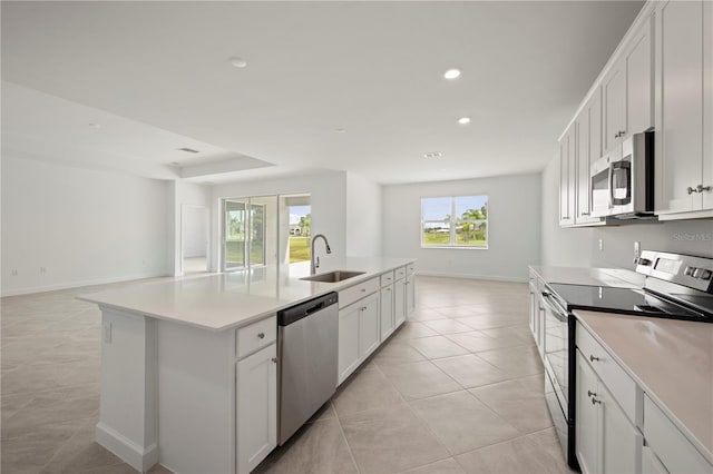 kitchen with white cabinets, a kitchen island with sink, appliances with stainless steel finishes, and sink