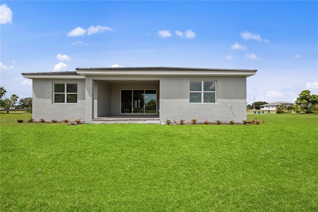 rear view of house featuring a lawn and a patio