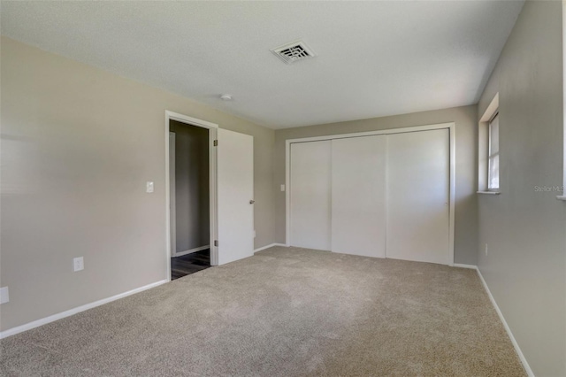 unfurnished bedroom featuring a closet and dark colored carpet