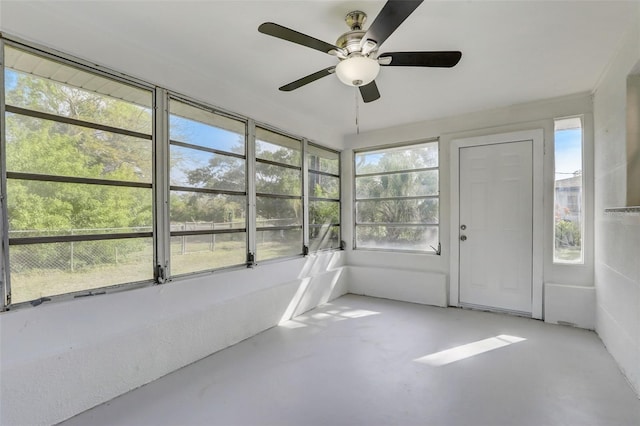 unfurnished sunroom featuring ceiling fan