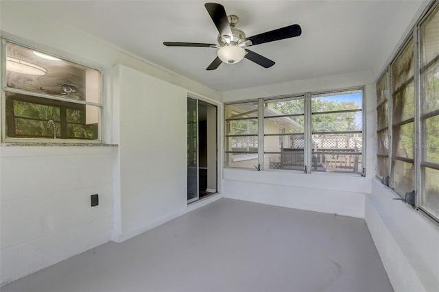 unfurnished sunroom featuring ceiling fan