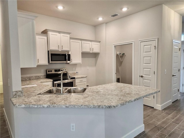 kitchen featuring white cabinets, kitchen peninsula, dark hardwood / wood-style flooring, and stainless steel appliances