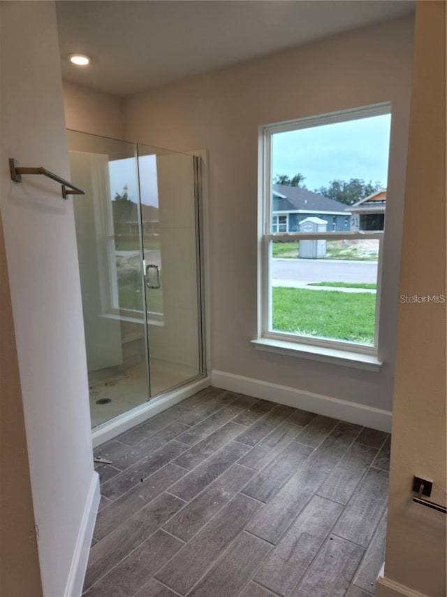 interior space with hardwood / wood-style floors and a shower with shower door