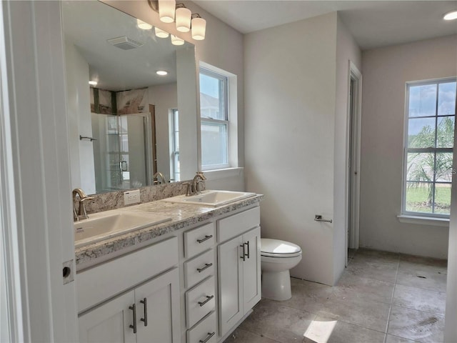 bathroom with double sink vanity, tile flooring, and toilet