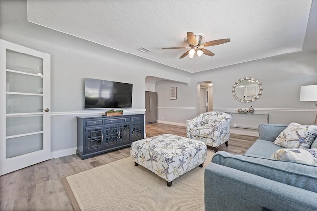 living room with ceiling fan and light wood-type flooring