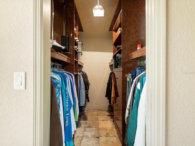 spacious closet with stone tile floors