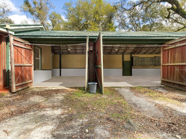 view of vehicle parking with a carport and an exterior structure