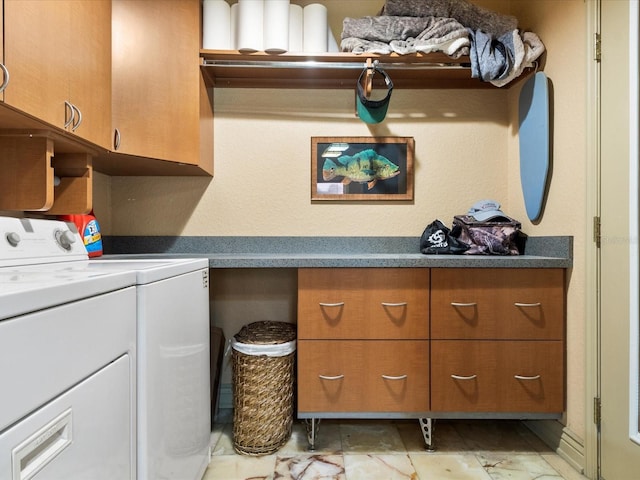 clothes washing area featuring washing machine and dryer and cabinet space