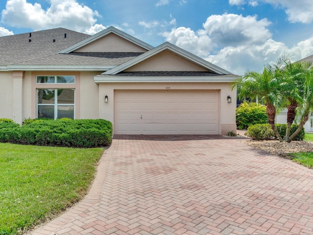 view of front of house featuring a front lawn and a garage