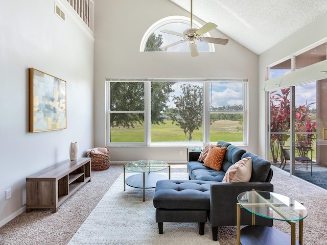 carpeted living room featuring high vaulted ceiling, a textured ceiling, and ceiling fan