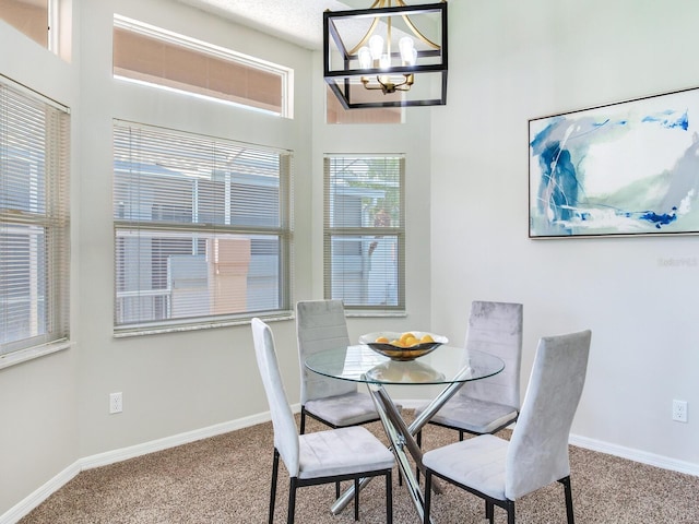 carpeted dining room with a chandelier