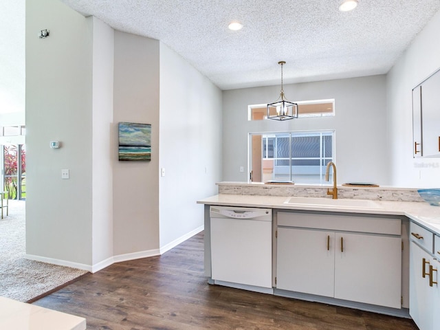 kitchen with pendant lighting, sink, dishwasher, dark wood-type flooring, and a textured ceiling