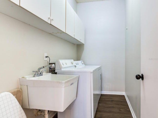 clothes washing area with cabinets, hookup for a washing machine, dark hardwood / wood-style flooring, washer and dryer, and sink