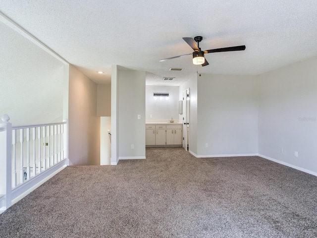 interior space with carpet, ceiling fan, a textured ceiling, and sink