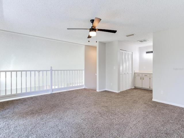 unfurnished room with carpet flooring, a textured ceiling, and ceiling fan