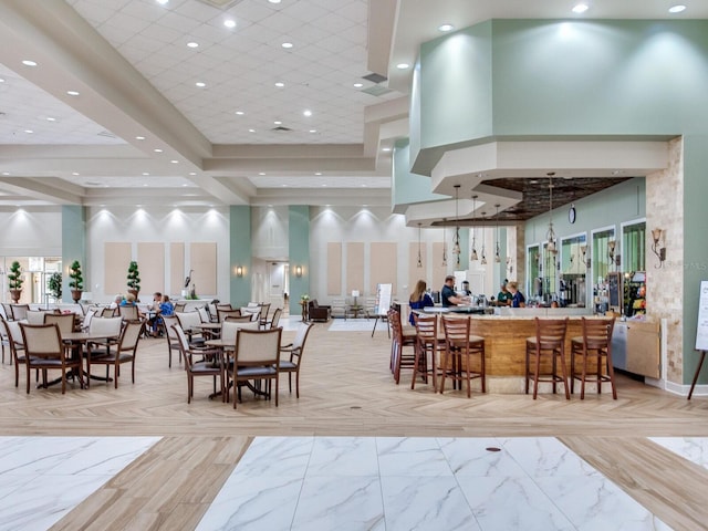 interior space with light tile flooring, bar area, and a towering ceiling