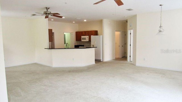 unfurnished living room featuring ceiling fan and light colored carpet