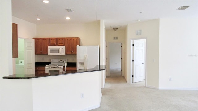 kitchen featuring white appliances and light carpet