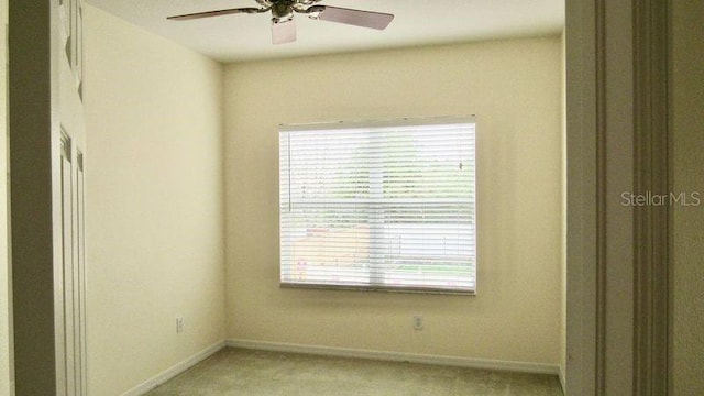 unfurnished room featuring plenty of natural light, ceiling fan, and light colored carpet