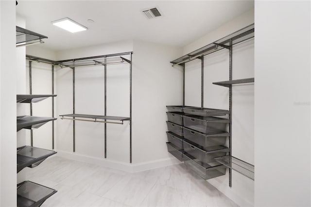 walk in closet with light tile patterned floors