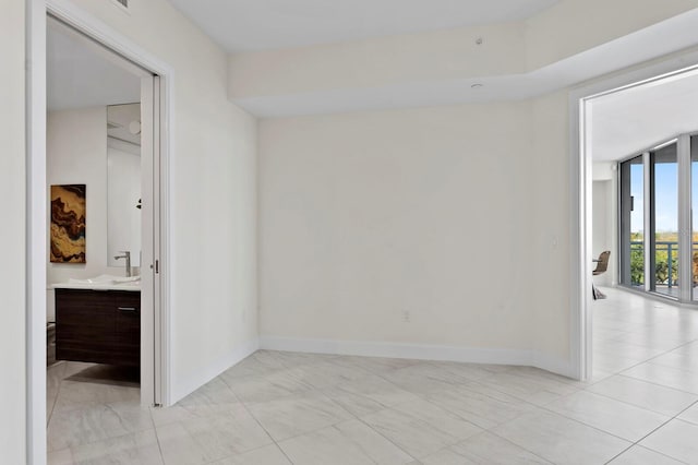 tiled spare room featuring sink