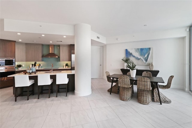 dining space featuring sink and light tile patterned floors