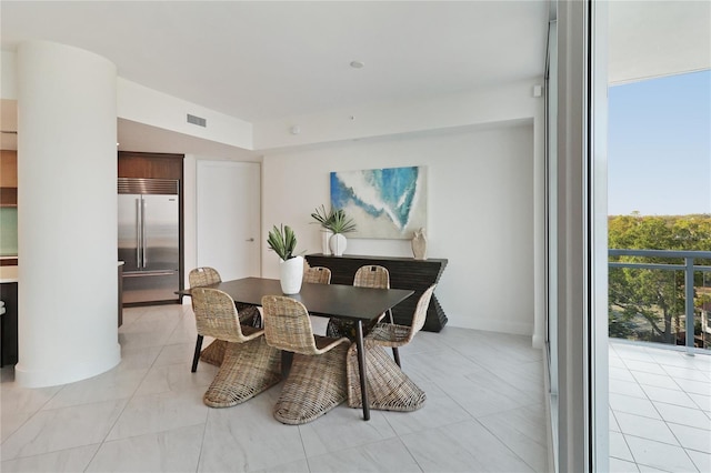 tiled dining room with floor to ceiling windows