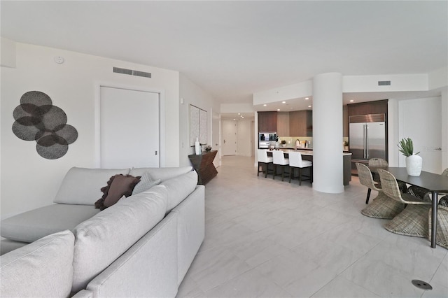 tiled living room featuring sink