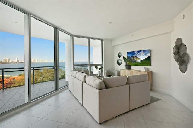 living room with light tile patterned floors, floor to ceiling windows, and a water view