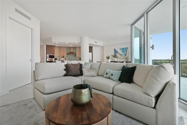 living room featuring a wall of windows and light tile patterned floors