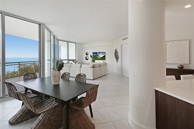 dining room with light tile patterned flooring and a wall of windows