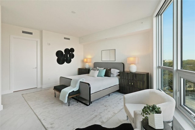 bedroom featuring light tile patterned floors and a wall of windows