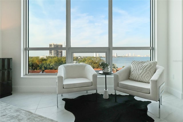 living area featuring light tile patterned flooring and a water view