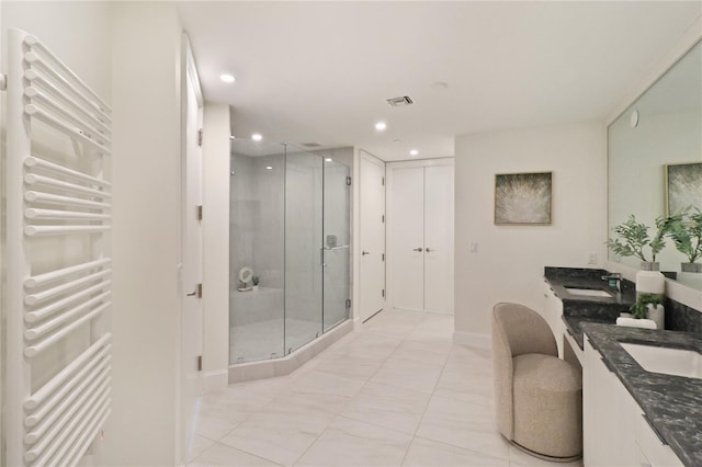 bathroom with dual vanity, an enclosed shower, tile patterned floors, and radiator