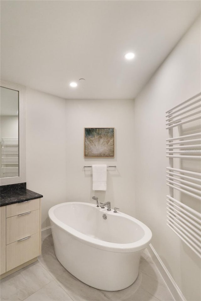 bathroom with a bath, tile patterned flooring, and radiator