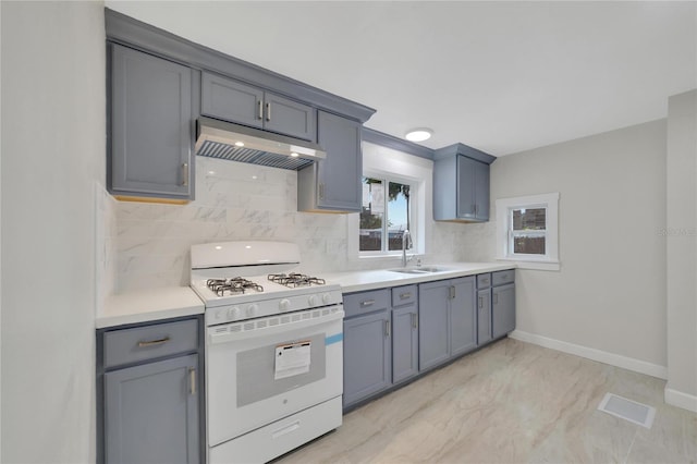 kitchen featuring gray cabinets, white range with gas stovetop, sink, and light tile floors