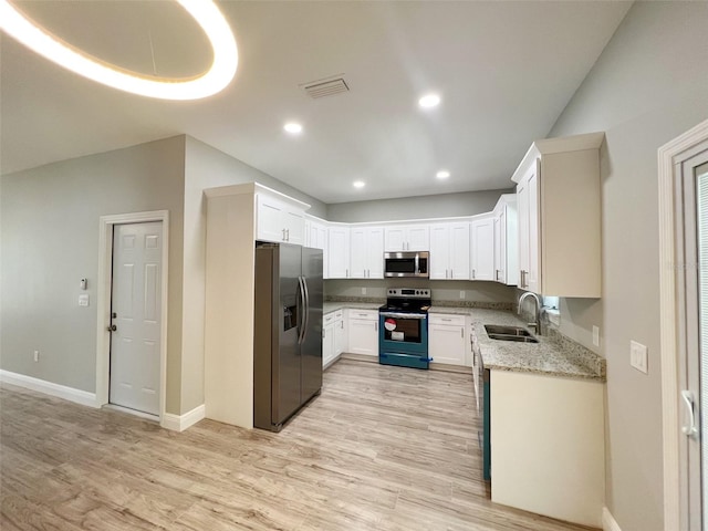 kitchen featuring white cabinetry, appliances with stainless steel finishes, sink, light wood-type flooring, and light stone counters