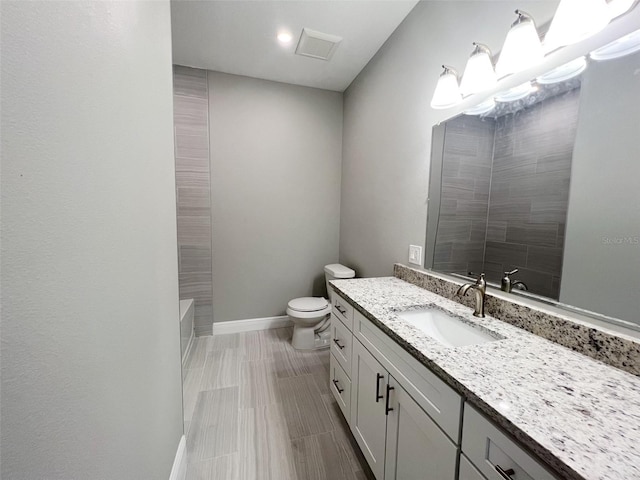 full bathroom featuring tile floors, vanity with extensive cabinet space, toilet, and tiled shower / bath