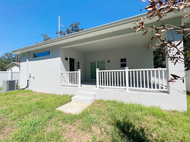 back of house featuring a lawn and central AC unit