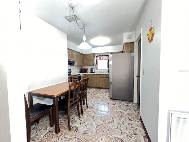 dining area featuring sink and light tile floors