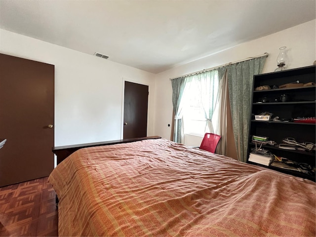 bedroom with dark parquet flooring