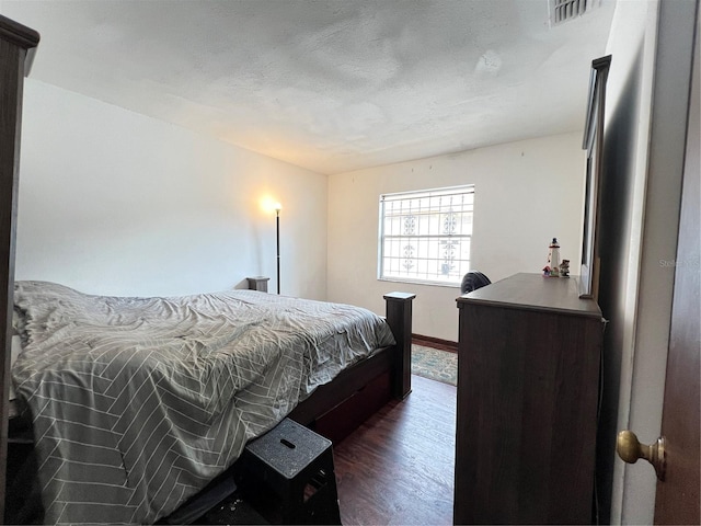 bedroom with dark hardwood / wood-style floors