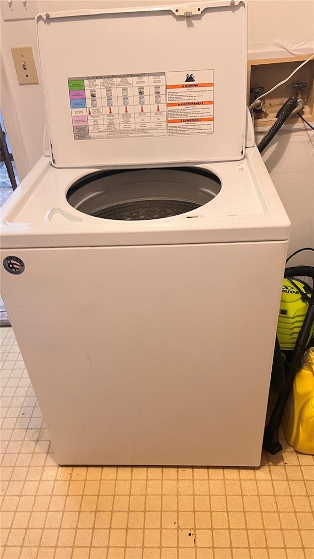 laundry area with light tile floors and washer / dryer