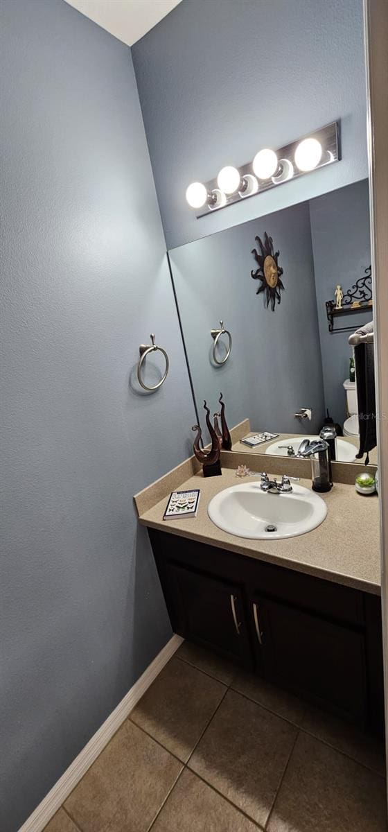 bathroom with tile flooring and vanity with extensive cabinet space