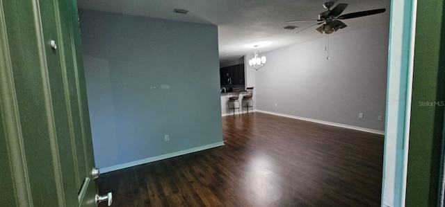 spare room with dark hardwood / wood-style floors and ceiling fan with notable chandelier