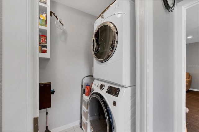 laundry area with light wood-type flooring and stacked washer and clothes dryer