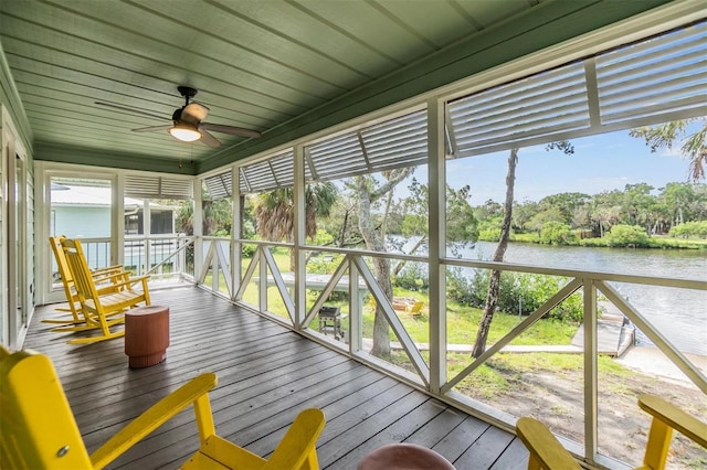 unfurnished sunroom featuring a water view and ceiling fan