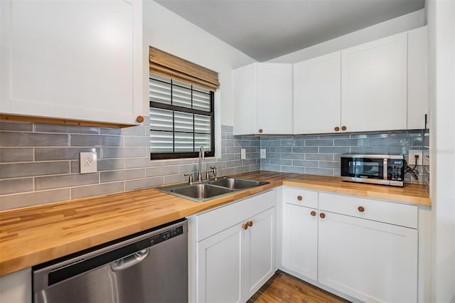 kitchen featuring appliances with stainless steel finishes, wood counters, and white cabinets