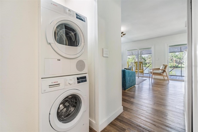 14640 W Black Creek Dr, Crystal River, FL 34429 - laundry area featuring stacked washer and clothes dryer, wood finished floors, and baseboards