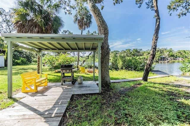 view of home's community with a deck with water view and a yard